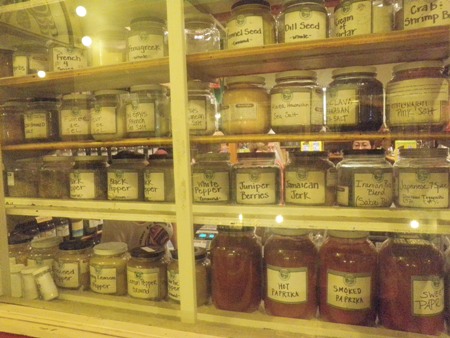 Jars of ground spices line the shelves of a MarketSpice window.