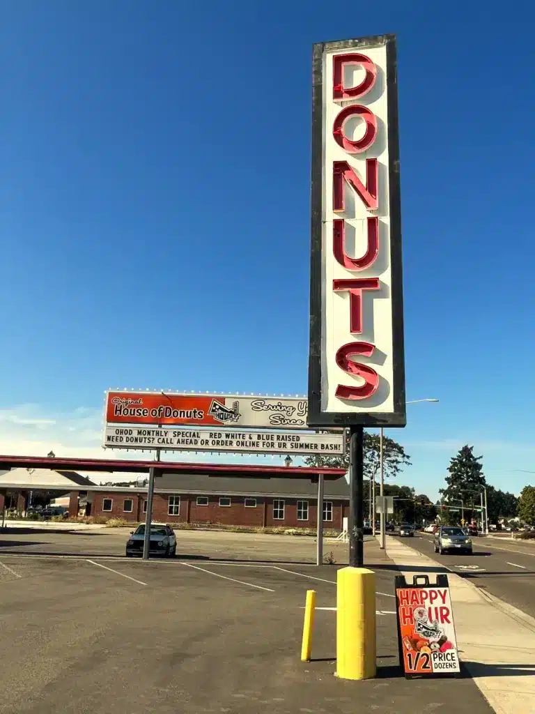 Parking lot view outside House of Donuts with the Store sign highlighting seasonal specials