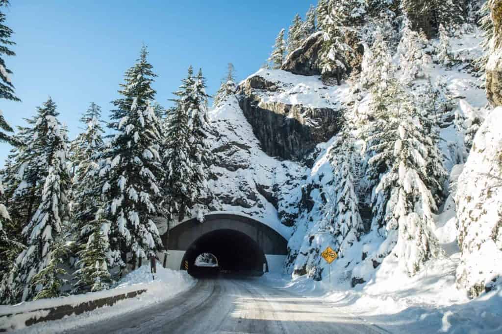 A snow covered tunnel surrounded by trees in the mountains - Washington state