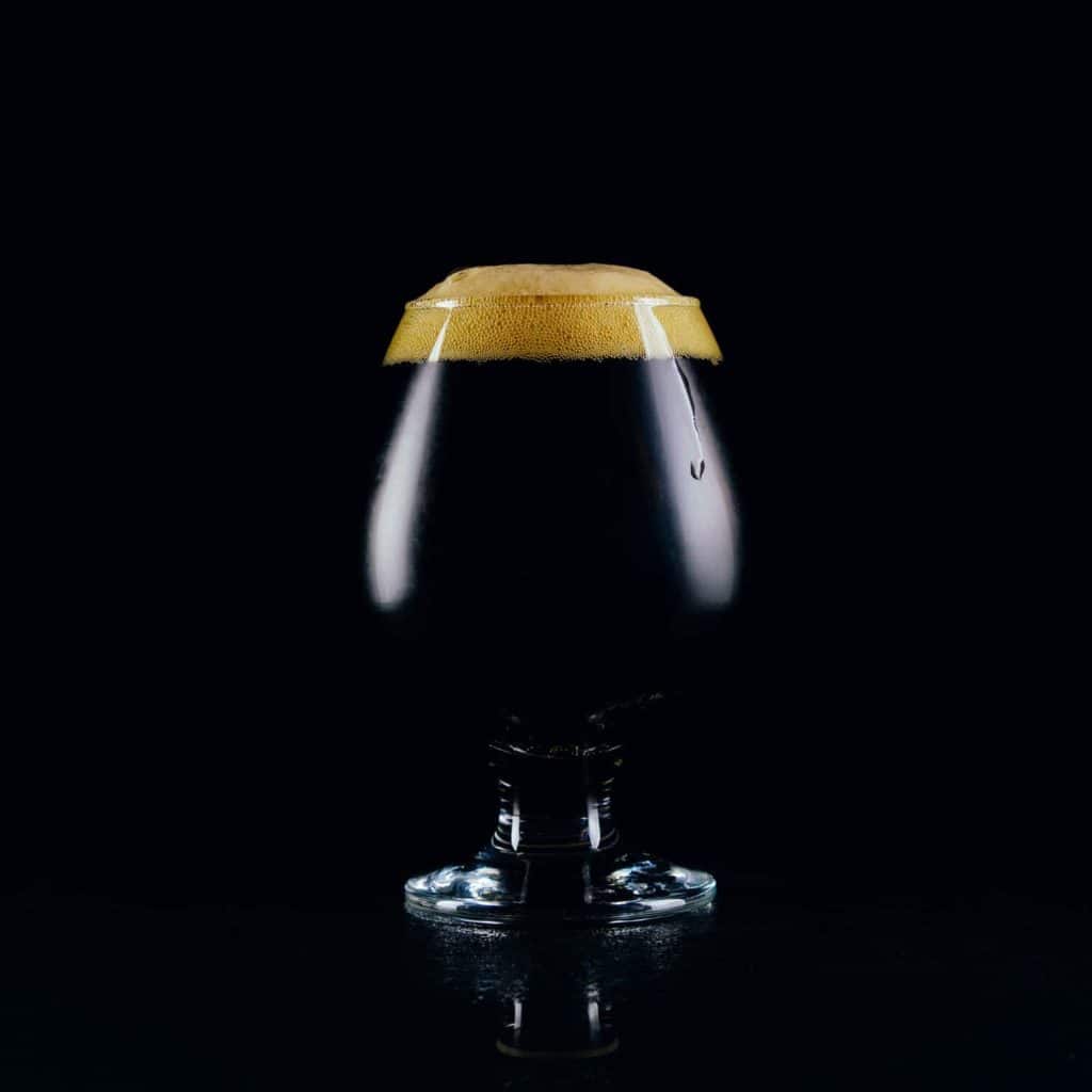 A glass of porter beer on a dark background